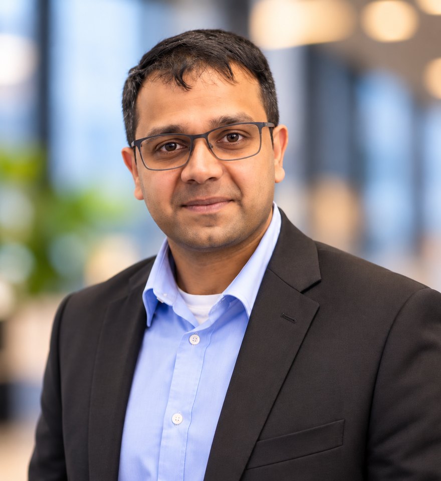 Portrait of Vineet Bro, smiling, in a dark blazer and light blue shirt